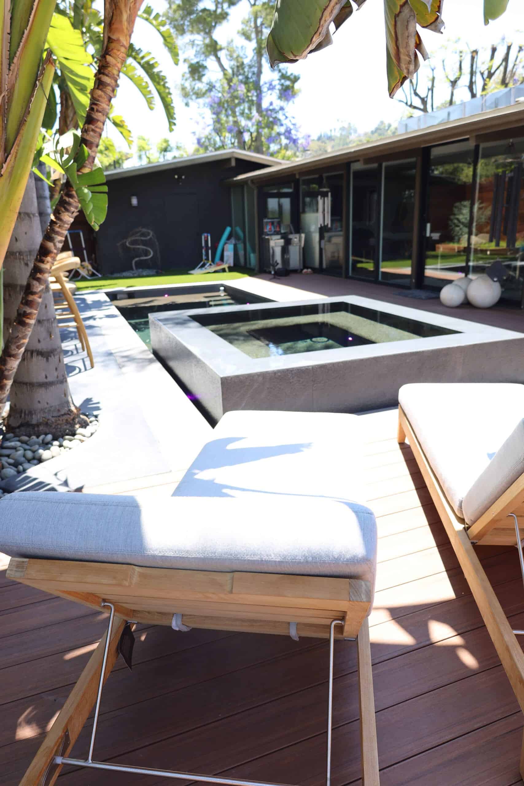 Raised square spa with a dark interior finish beside an ipe pool deck